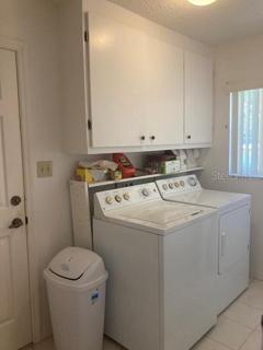 Inside laundry with washer and dryer. Upper laundry cabinets. Window for good lighting.
