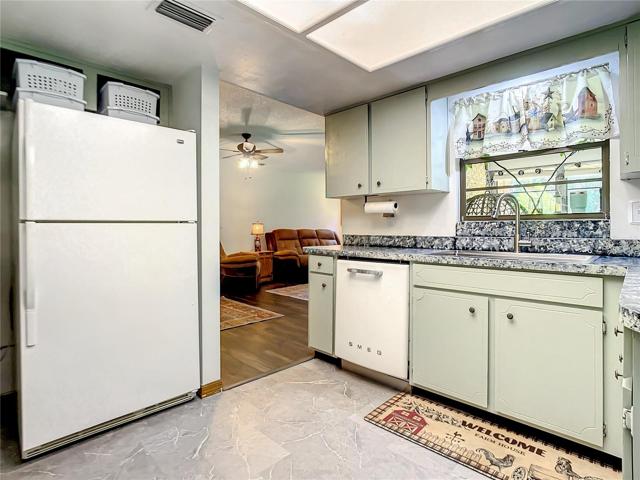 Kitchen window looks out into enclosed porch and back yard