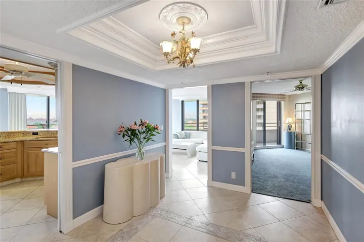 Entry Foyer to Kitchen, Living room & 3rd Bedroom/Den. Custom details in coffered ceiling & chair rails.