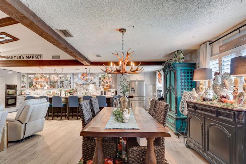 The open concept is bright and spacious with VAULTED CEILINGS and WOOD BEAM accents, plantation shutters, skylights, a fireplace with a brick surround and designer touches everywhere you turn including in the gorgeous kitchen!