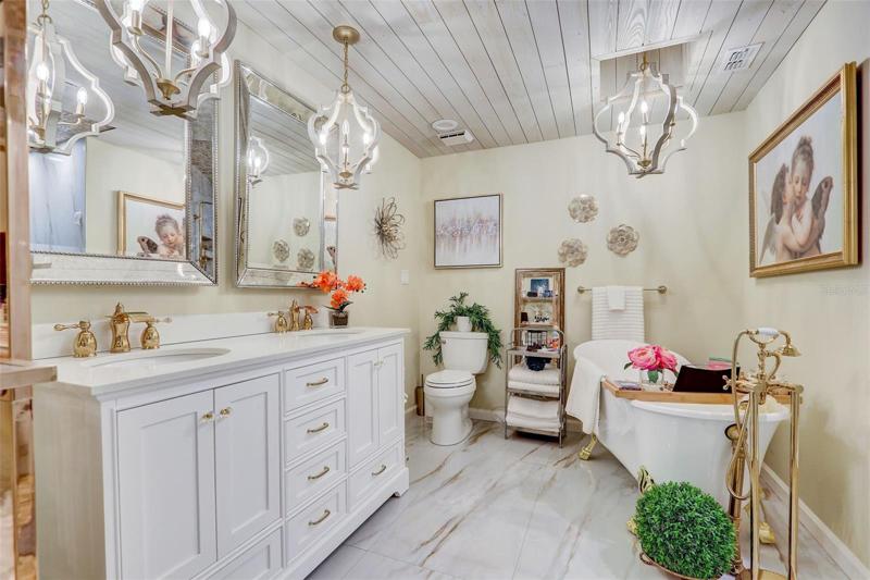 A clawfoot tub awaits in your private bath as well as a dual sink vanity under fabulous light fixtures, decorative mirrors and an oversized custom shower with dual/rain showerheads, bench seating and built-in shelves!