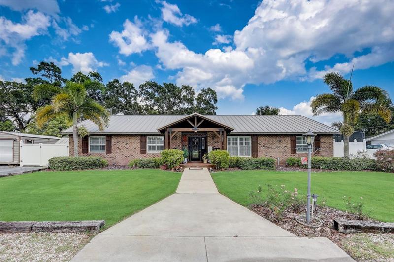 The brick exterior, wood shutters and covered front porch under a wood slat ceiling deliver an unmatched curb appeal and multiple sheds on the property give you plenty of storage options!