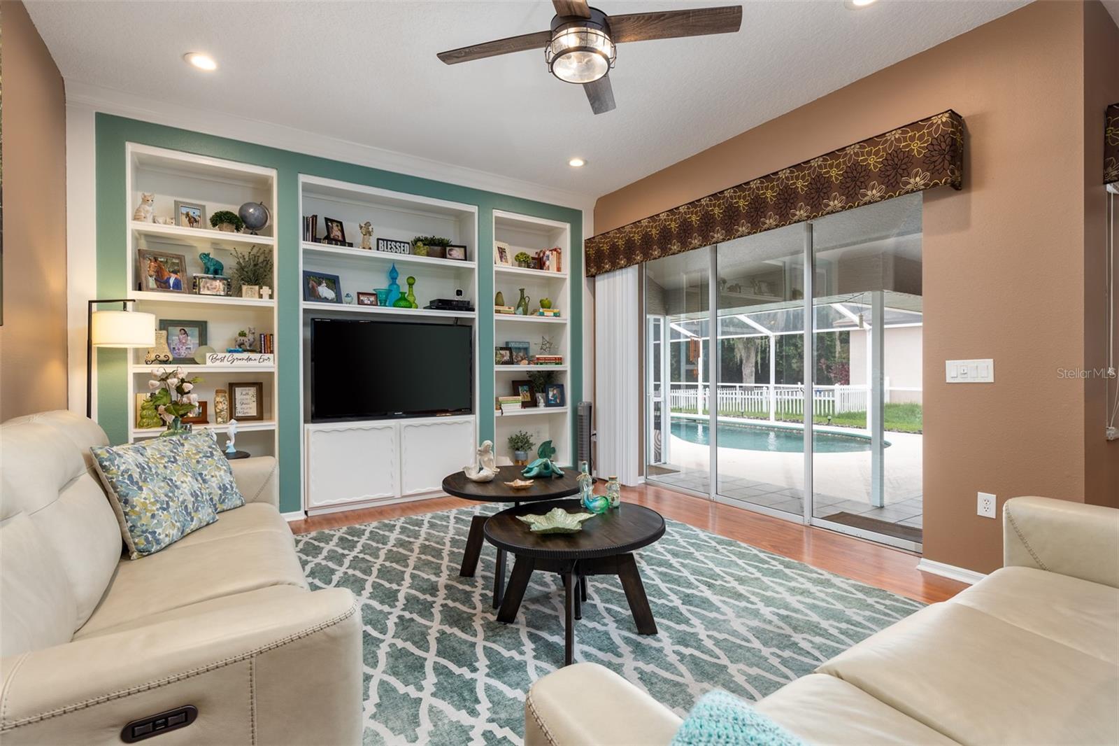 Alternate view of the Family Room showing  the wall of Built In Bookcases as well as the Sliding Glass doors leading out to the Lanai.