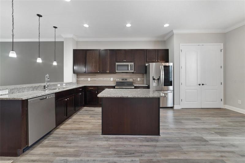 The spacious kitchen delivers all NEW UPGRADED APPLIANCES (2022), plenty of cabinet and counter space, including an ISLAND with seating, closet pantry and BREAKFAST BAR under pendant lighting for casual dining or entertaining!