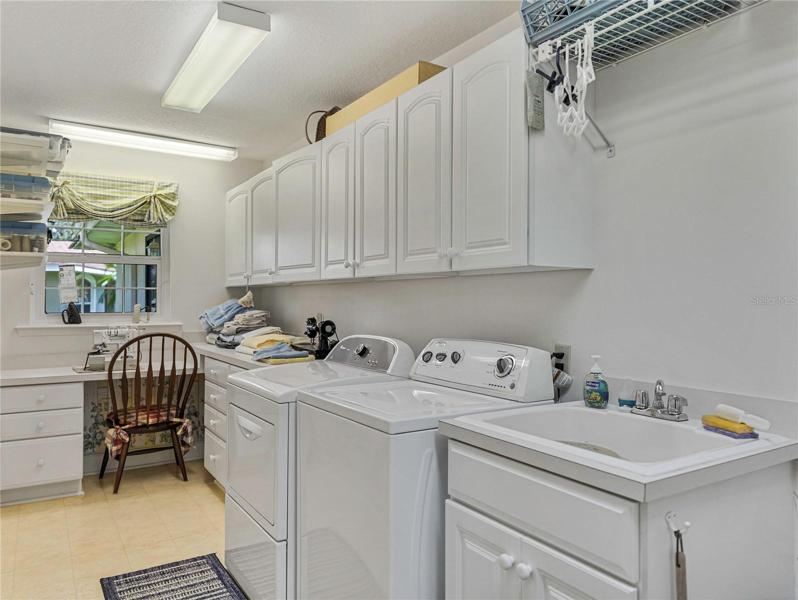 Inside Laundry room with utility sink, sewing area and lots of cabinet storage