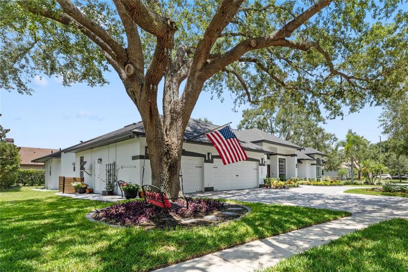 The home features a large circular driveway and mature trees.