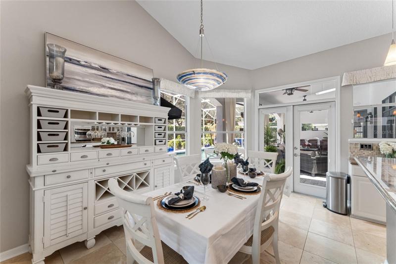 The kitchen features a sunny breakfast room with French door access to the pool deck.