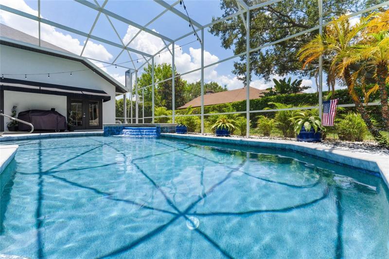View of pool and spa with screened enclosure.