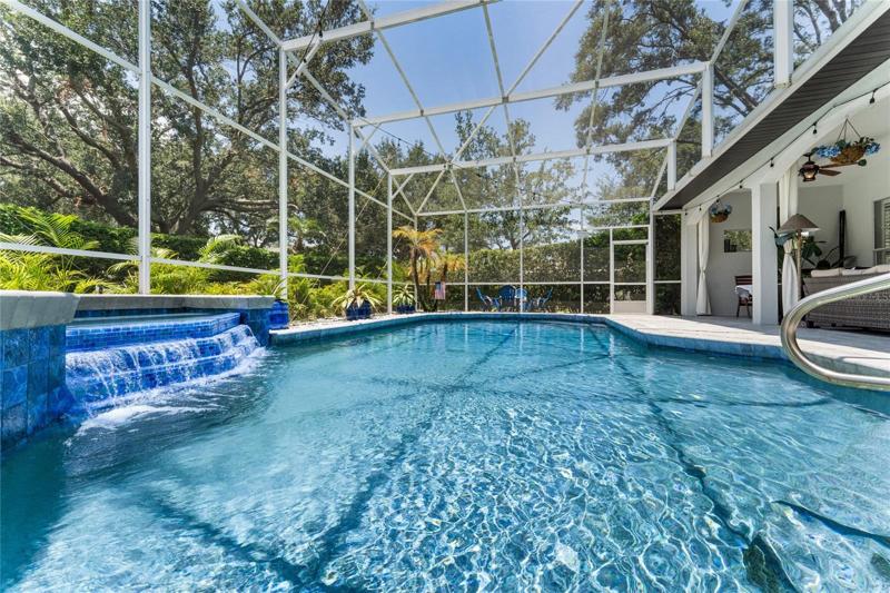 View of pool and spa with screened enclosure.