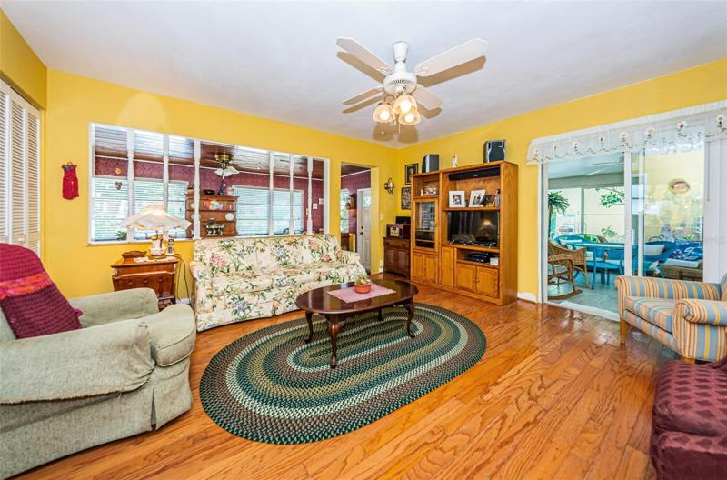Spacious Family Room is centrally located in the house - it opens up to Dining Area/Enclosed Front Porch and Florida Room, as well as Kitchen, Second Bedroom Ensuite and Guest Bath.