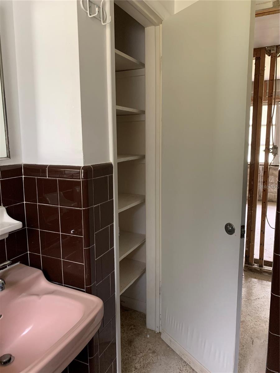 Bathroom has built in shelving.