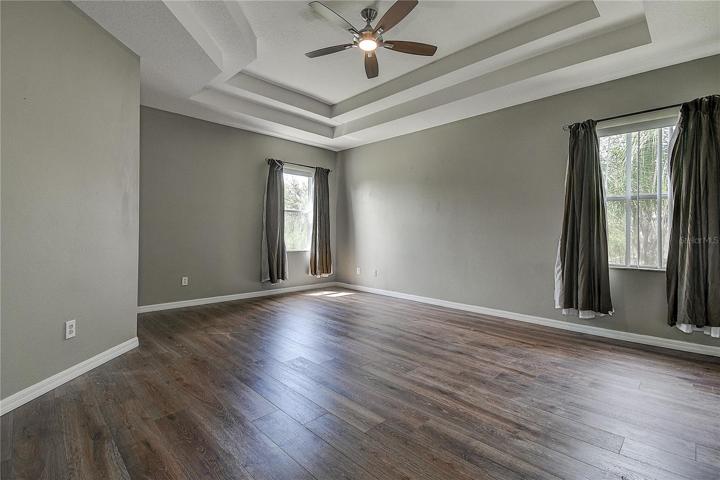 Large master bedroom with lovely celing and fan.