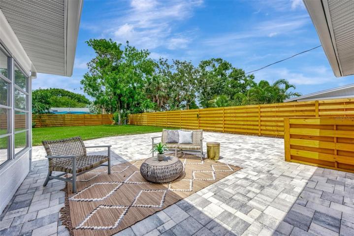 Pavered patio and view of the enormous backyard with brand new shadowbox fence