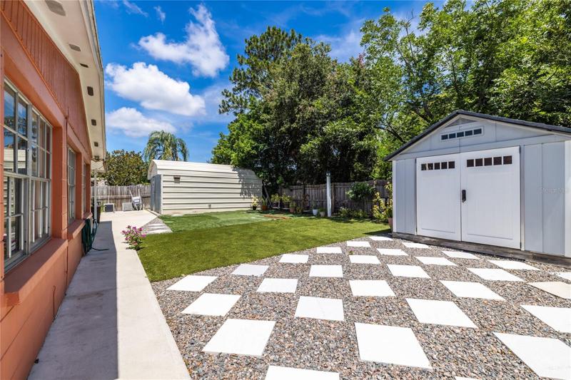 Backyard view. Shed in the back used for storage. The grass is artificial.