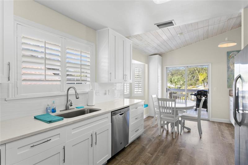 Large and bright kitchen with table for meals. Lots of sunshine coming through the sliders and Plantation Shutters.
