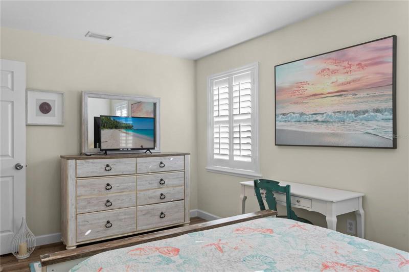 This bedroom has plenty of room for the dresser as well as the desk.
