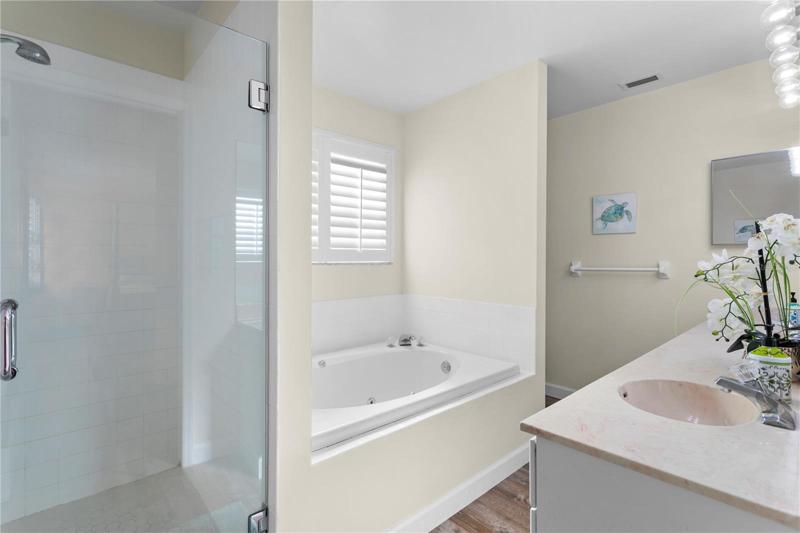 The en suite bathroom has a separate shower, jacuzzi tub, and double sink vanity.