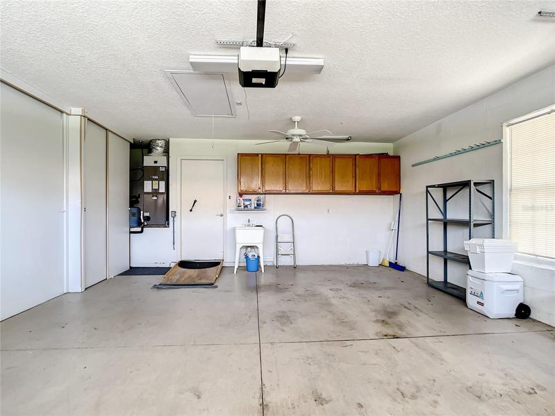 Large 2 car garage with lots of built in storage and a utility tub.