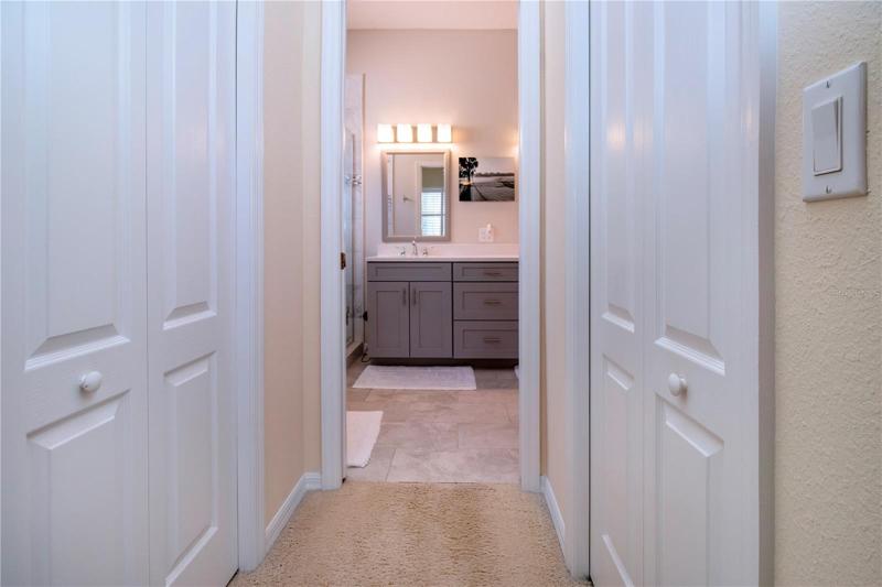 hallway to en suite bath with two closets
