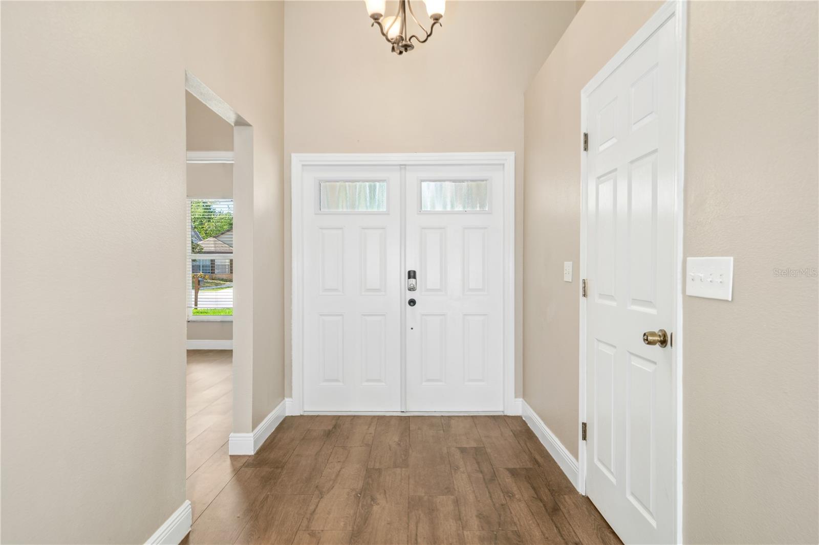 Wood look tile flooring welcomes you into the expansive foyer with double front doors