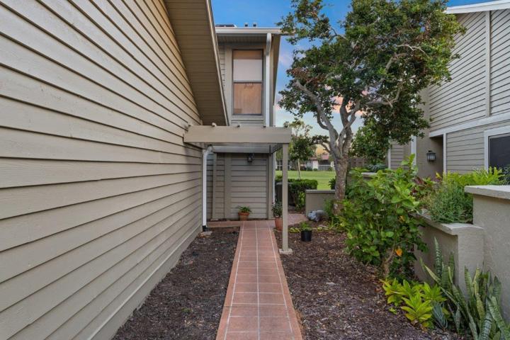 Front walkway surrounded by mature landscaping with views of the golf course.