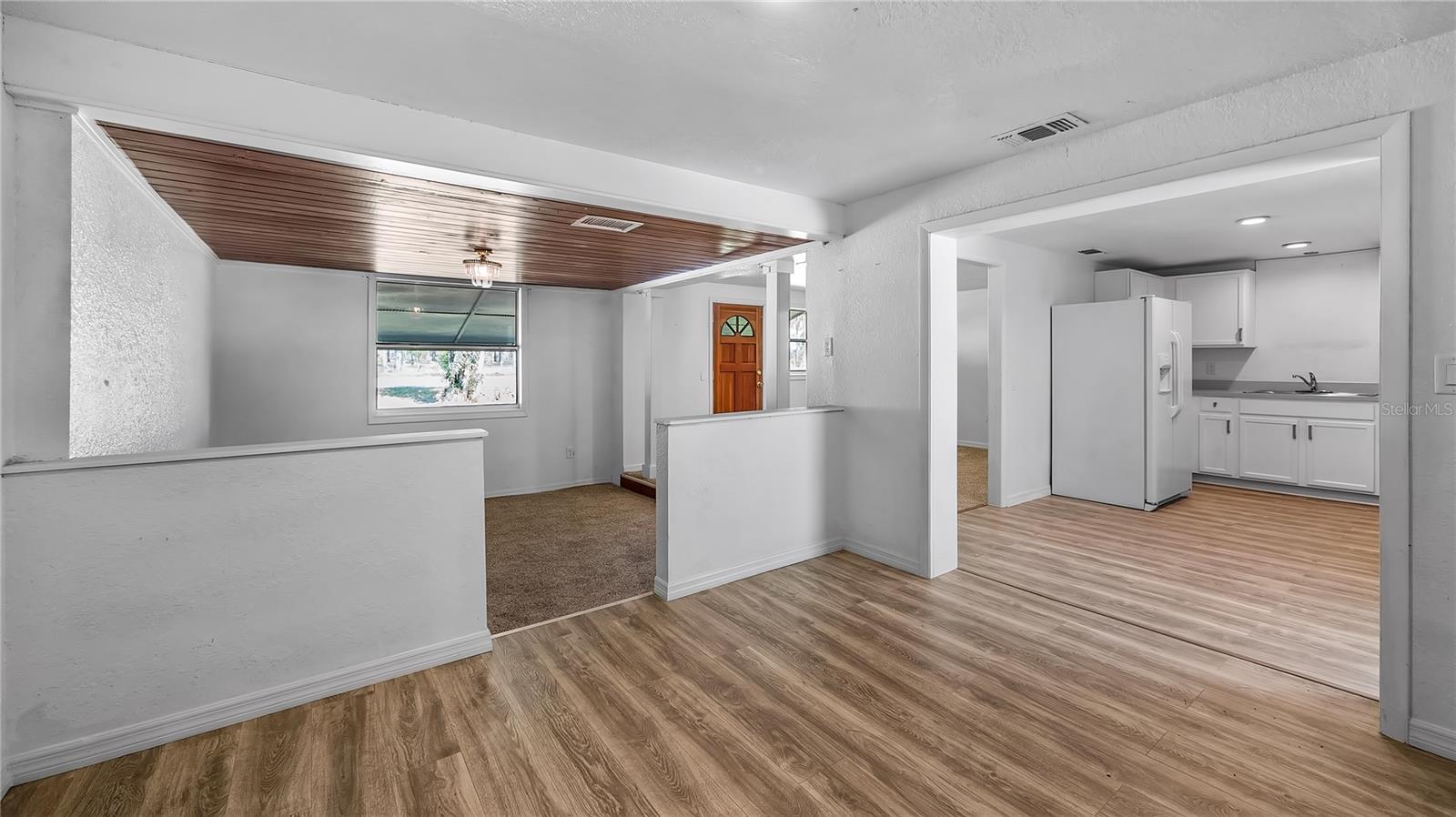 Dining room space looking in to kitchen and extra space off of living room that could be an office