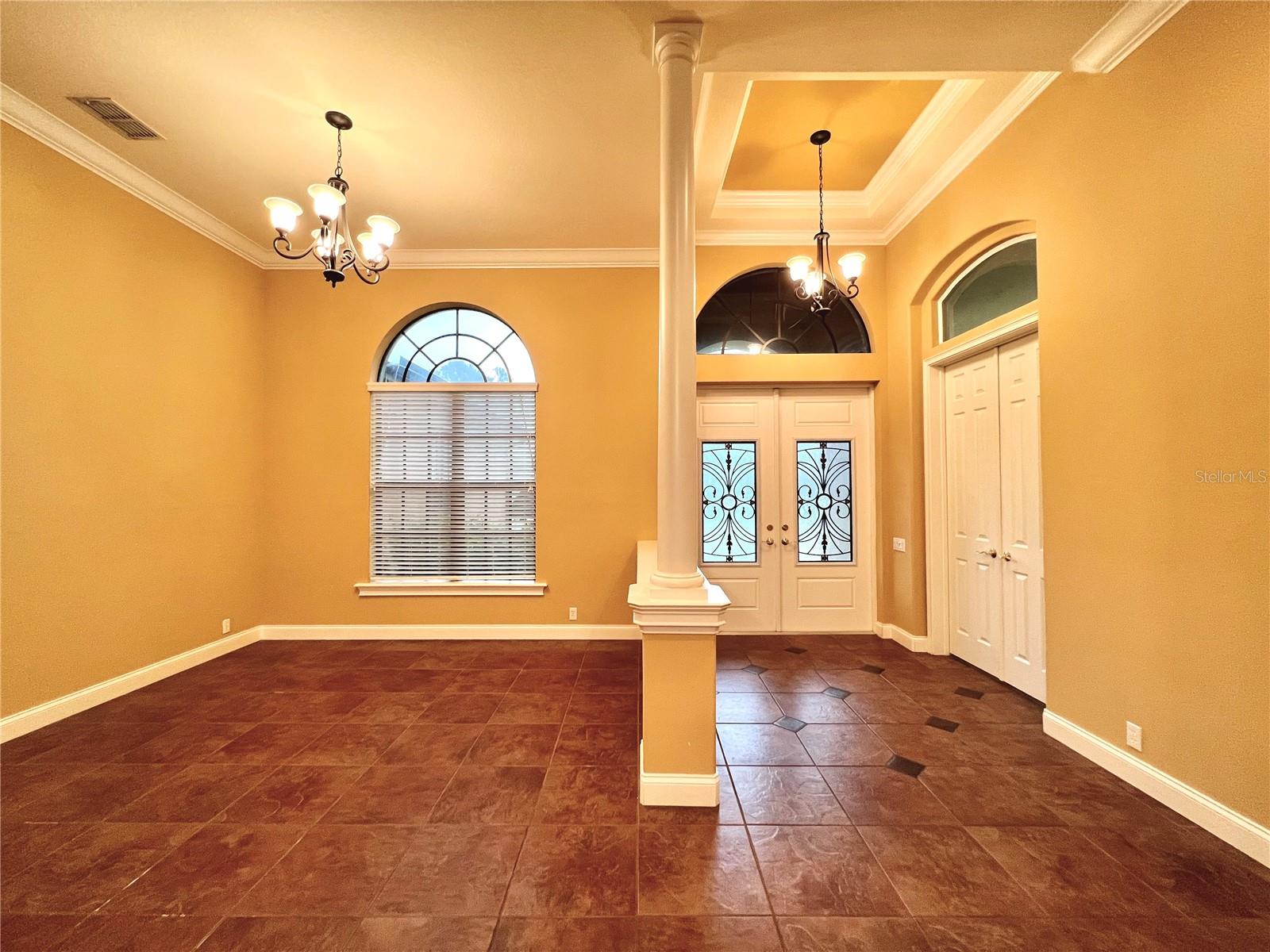 Pretty dining area &amp; foyer entrance  w/ ornate front door &amp; trey ceiling with moulding
