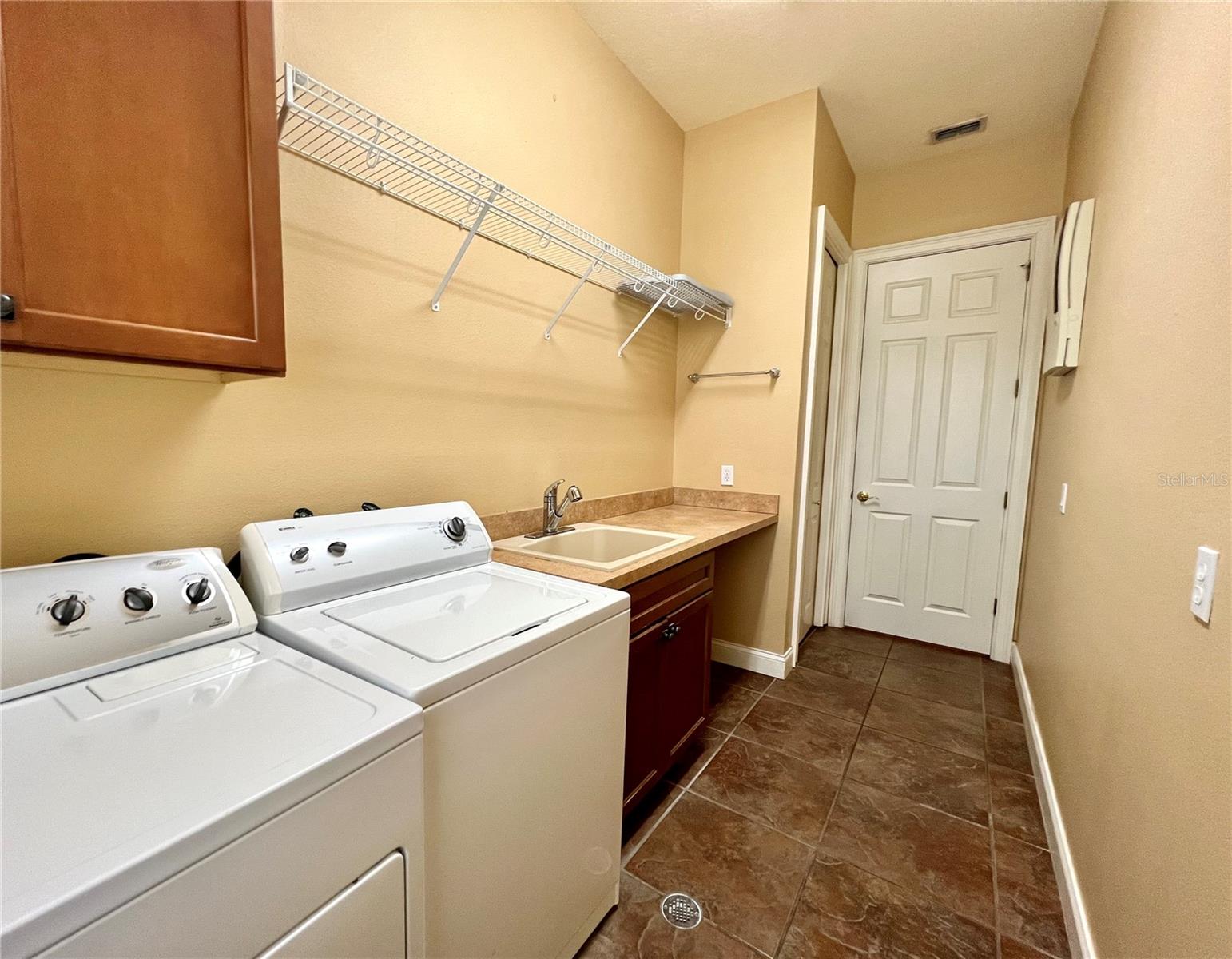 Nice size laundry rm complete w/ folding countertop, washtub &amp; floor drain