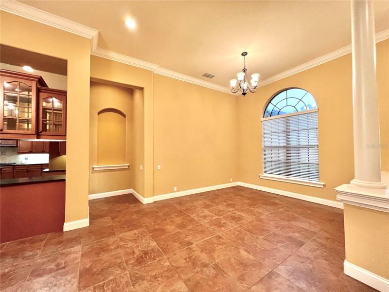 Another view of dining area w/ ornate niche leading to kitchen
