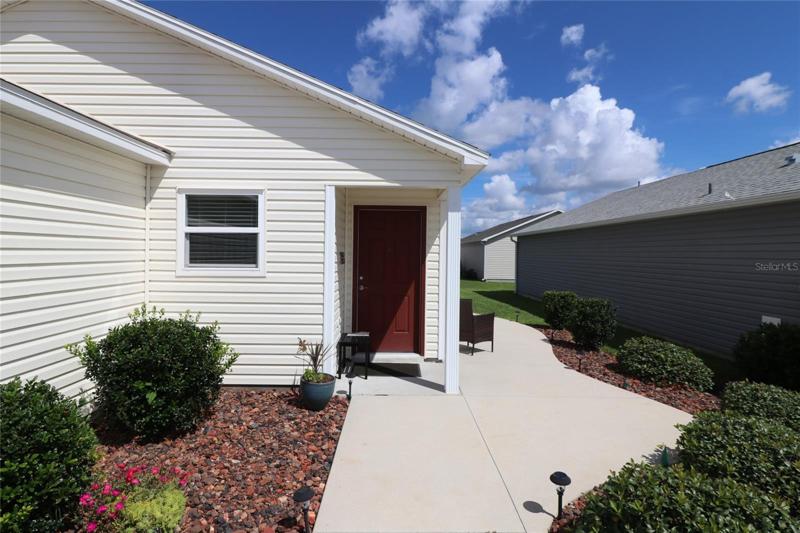 Front door and sidewalk to the side of the home.