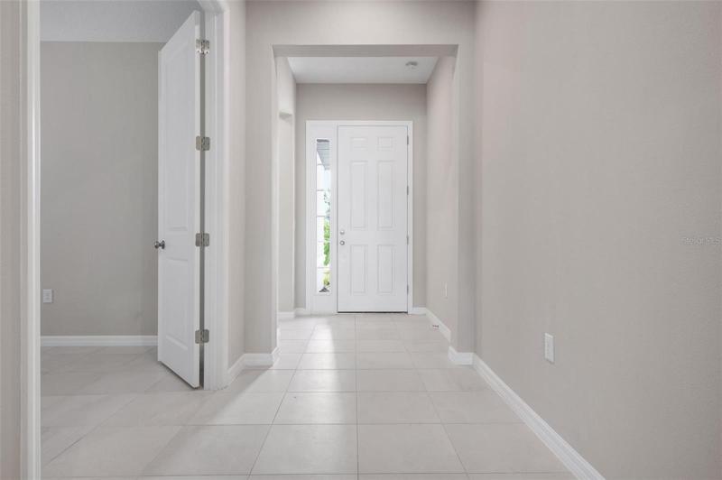 front entry door from near kitchen with den on left