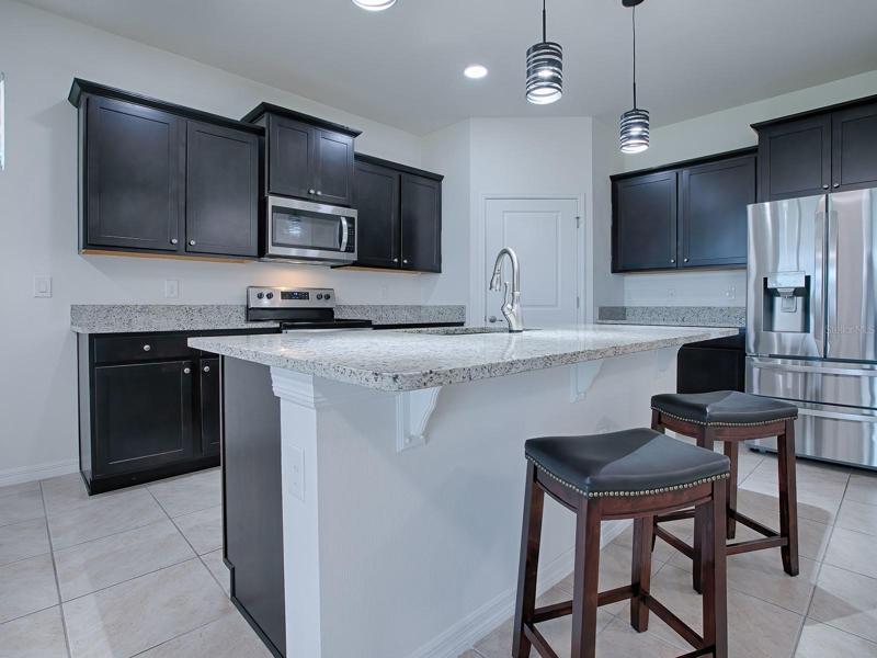 THE KITCHEN HAS A BREAKFAST BAR, STAINLESS STEEL APPLIANCES, A CLOSET PANTRY AND MORE...