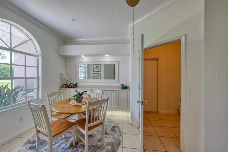 Eat-in kitchen/dinette area with built-in cabinets with stone top. Interior laundry room to the right.