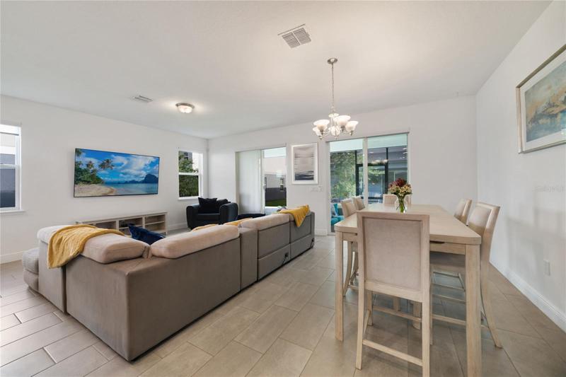 Two sets of sliding glass doors let natural light pour into the open living and dining spaces with tile floors for easy maintenance and open to the kitchen making entertaining a breeze!