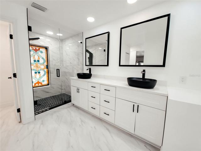 White Shaker Style Vanity with Dual Vessel Sinks in Matt Black, Walk in Shower with Window Accent