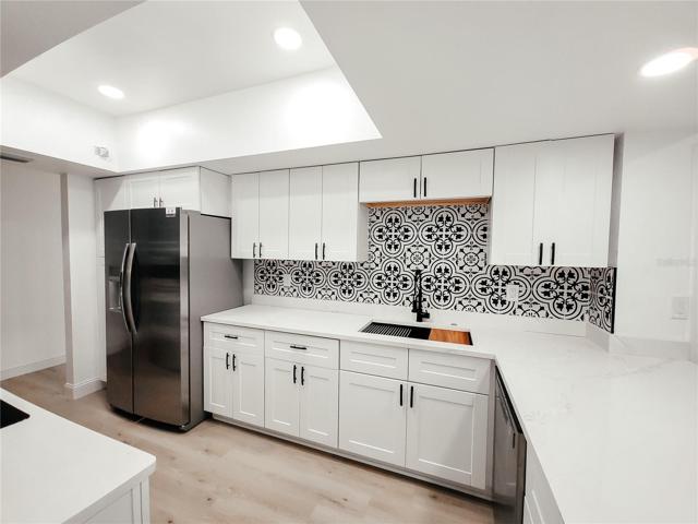 Black and White Tile Backsplash adds that modern touch, White Granite with a Grey Vein and conversation bar open to the Dinette