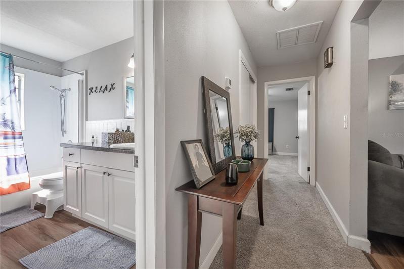 The hallway on the other side of the home, leading to two bedrooms and bathrooms.