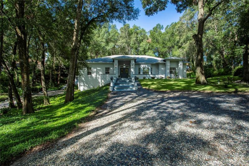 201 Pond Road welcomes you home to your private and tranquil retreat on this lushly wooded and landscaped acre plus lot that is just over a mile to downtown Mount Dora.