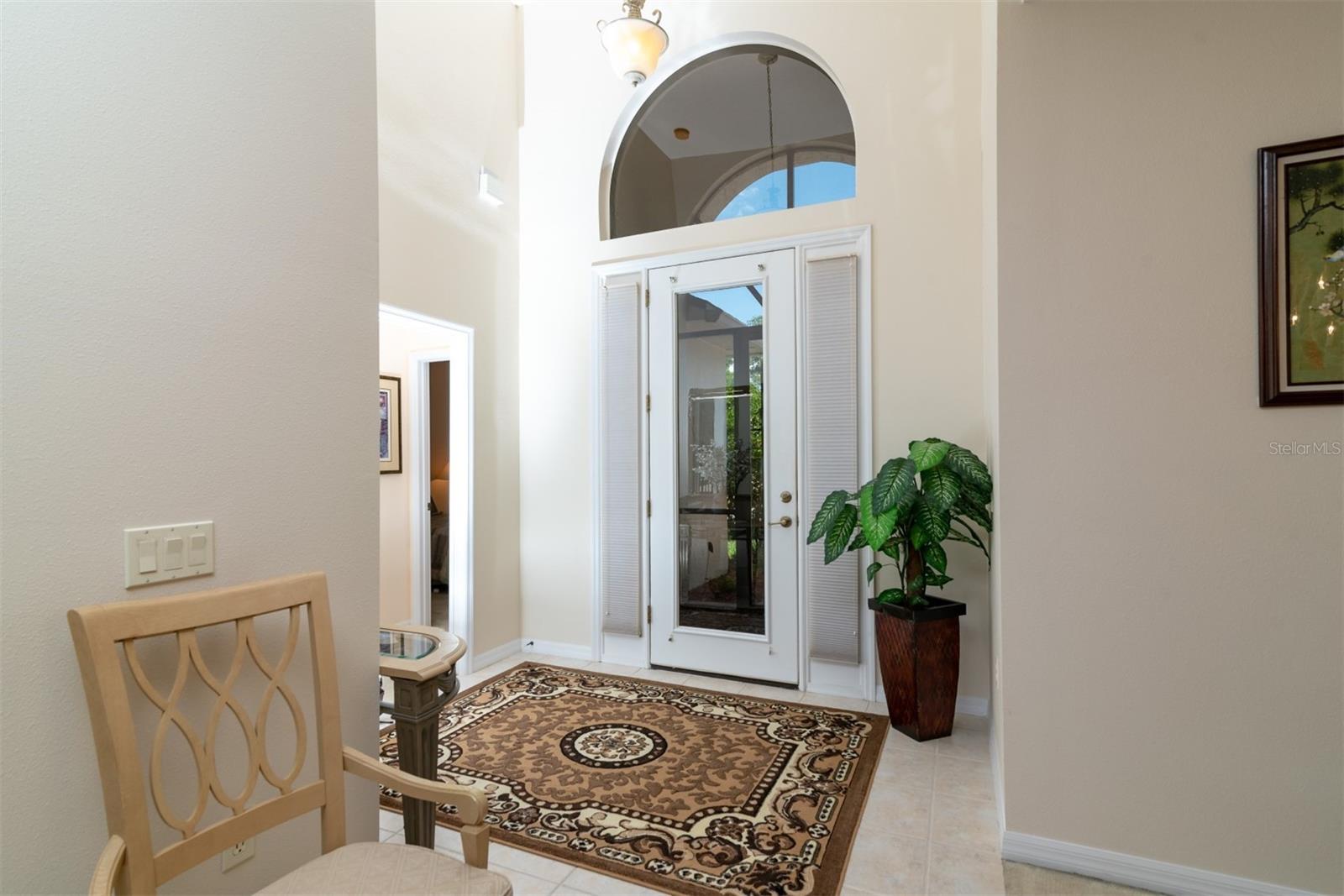 The vaulted foyer gets great natural light from the over the transom arched window, full glass front door and sidelights.