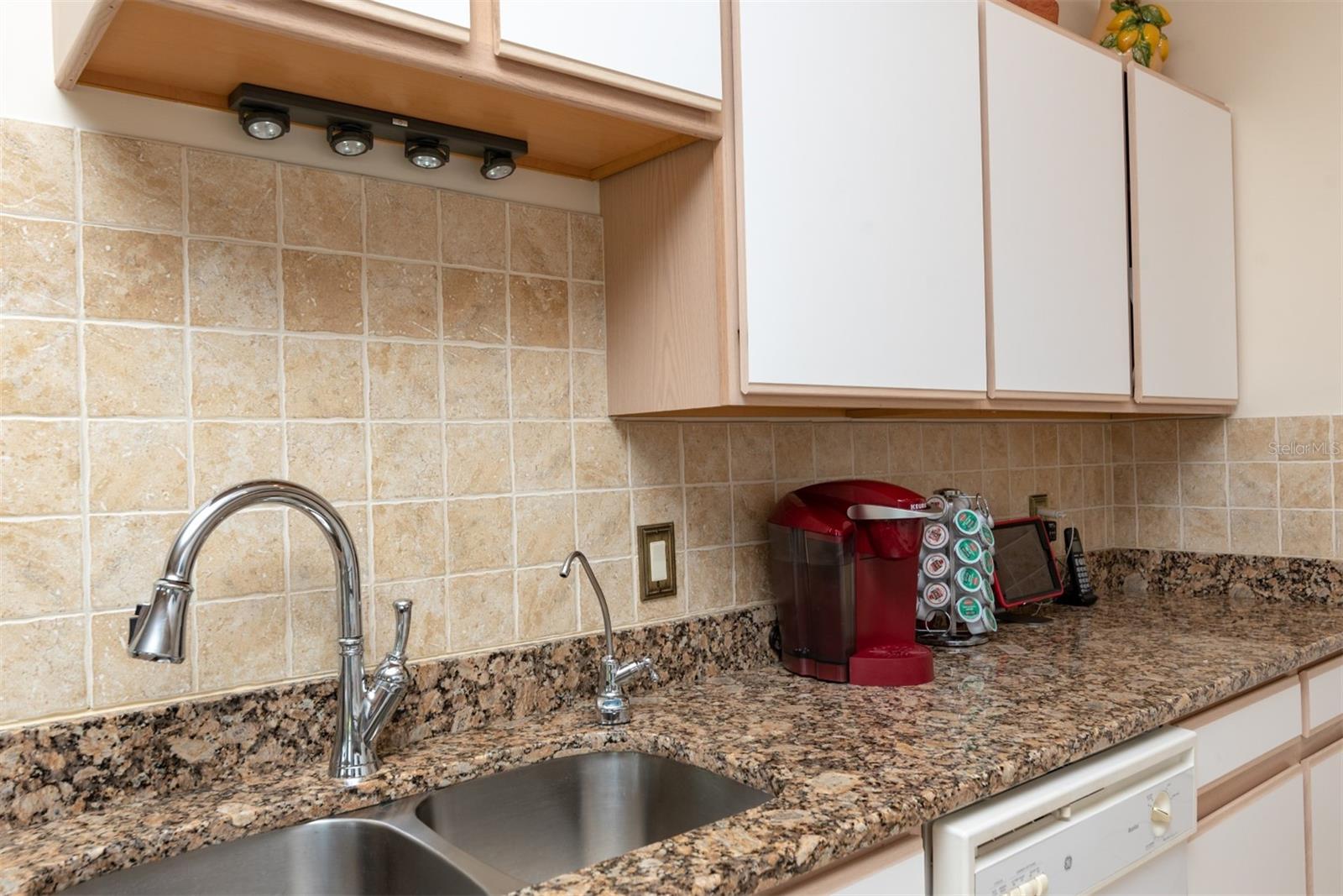 The upgraded plumbing fixture and reverse osmosis system enhance the kitchen.