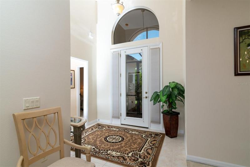 The vaulted foyer gets great natural light from the over the transom arched window, full glass front door and sidelights.