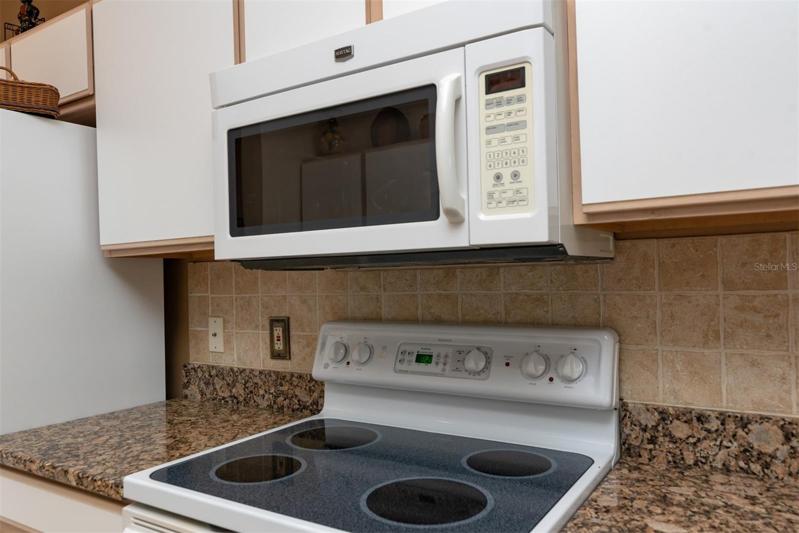 The tile backsplash adds a touch of class to the kitchen and enhances the granite counters.