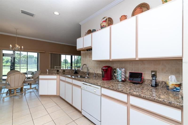 The granite countertop, tile backsplash and crown molding enhance the kitchen.