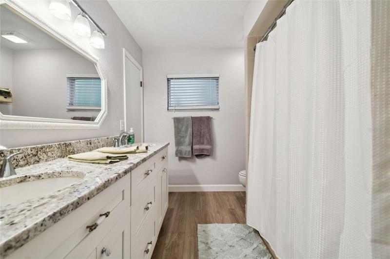 New countertops and cabinetry and once again, there are those vinyl plank floors! This guest bath also includes a tub to wash off those dirty pets or kids