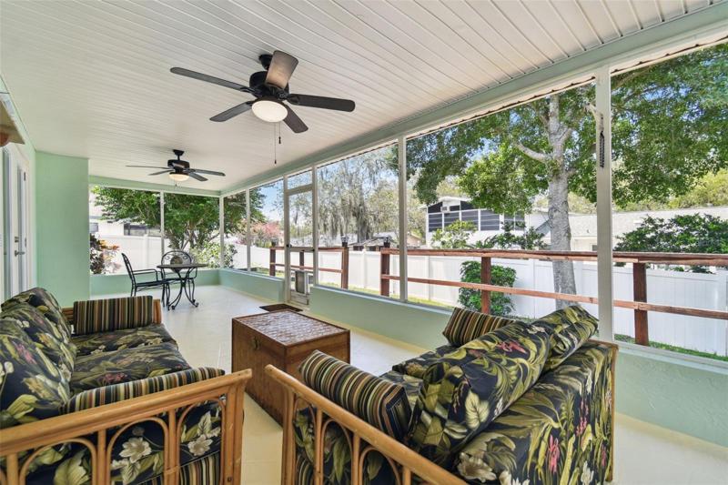 Up your screen time game in the beautifully updated screened-in lanai that runs the back of the house