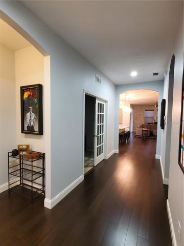 view from front door. First bedroom and bathroom are to your left and second bedroom, laundry and garage are to your right. Great room is at the end of the entry corridor. The double doors on the left is the entrance to the den/game room/office.