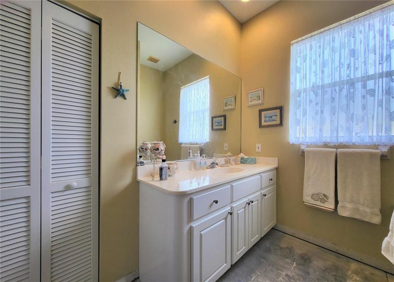 Vanity has cabinets and drawers. Linen closet on the left