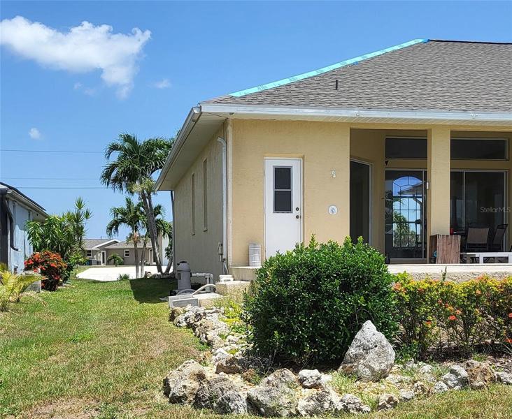 One side of the home looking towards the street. Note the outdoor shower to the right of the pool half-bath
