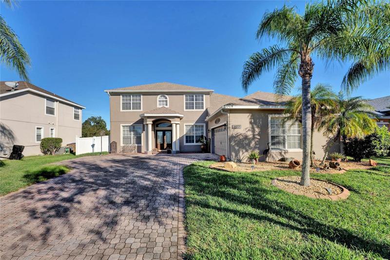 Beautiful paved driveway leading to three car garage