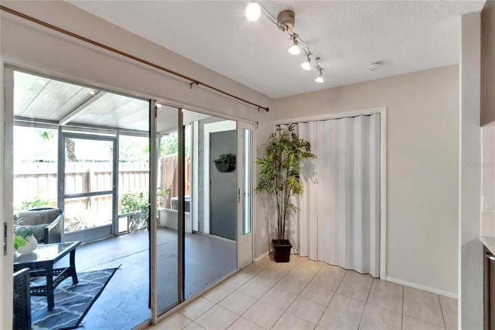 Kitchen with laundry closet and view into patio area.